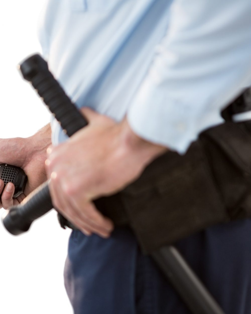 Mid section of security officer holding a walkie-talkie Mid section of security officer holding a walkie-talkie